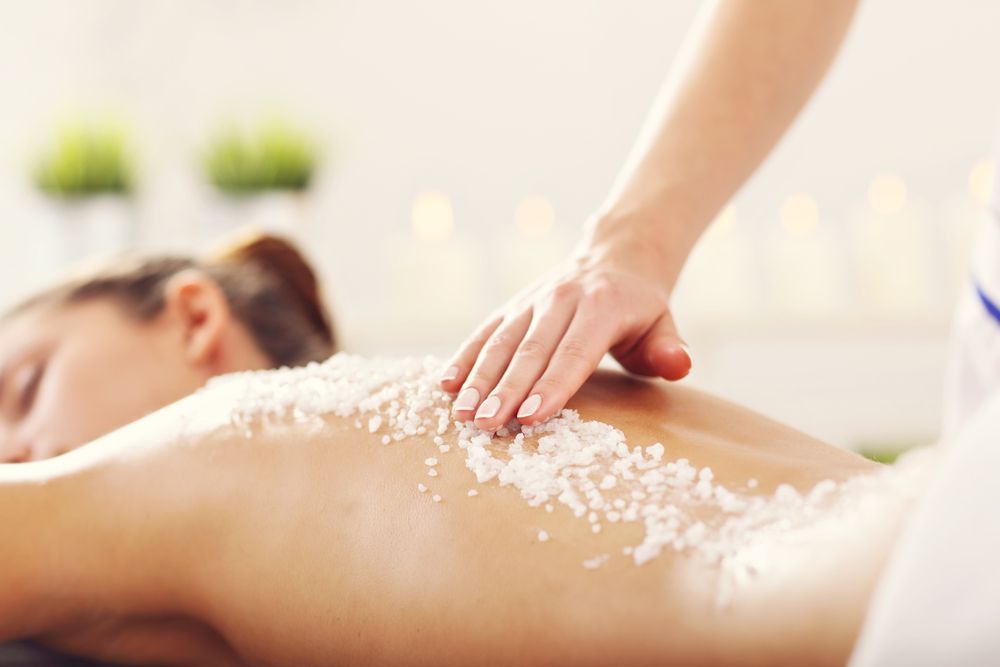 Massage Therapist Applying Scrub to Clients Back in A Spa Setting — Figtree Day Spa in Sawtell, NSW