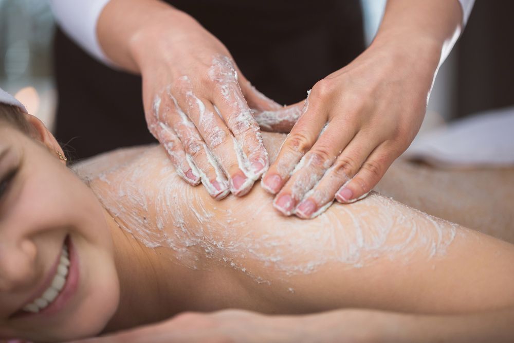 A Woman Is Getting a Body Scrub at A Spa — Figtree Day Spa in Sawtell, NSW