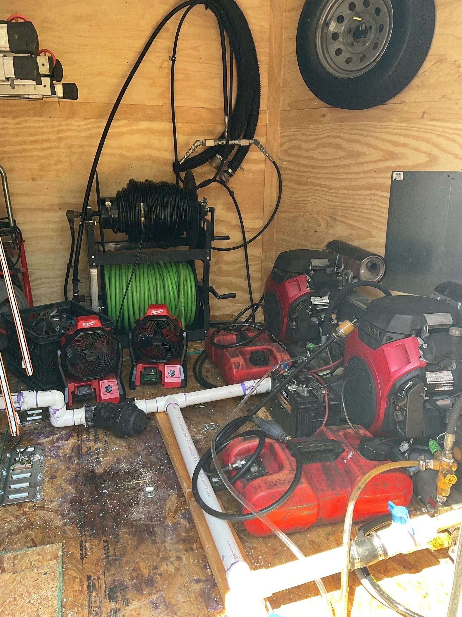 A bunch of tools are sitting on the floor in a trailer.