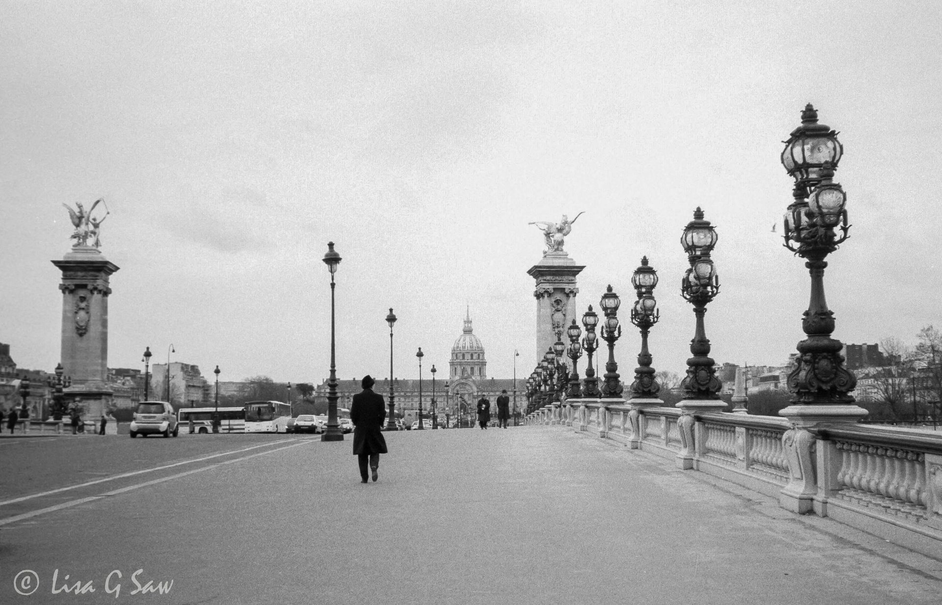 Man walking across Pont Alexandre III bridge in Paris
