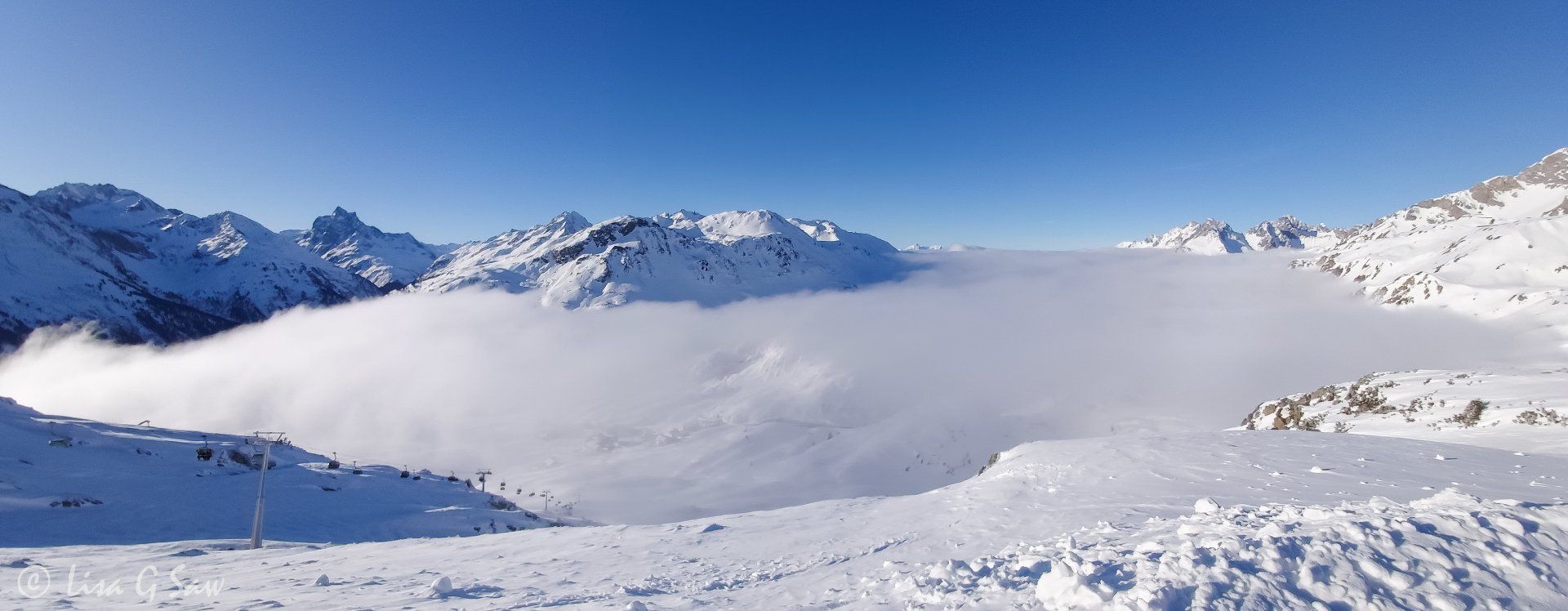 Ski resort and snow covered mountains with low cloud