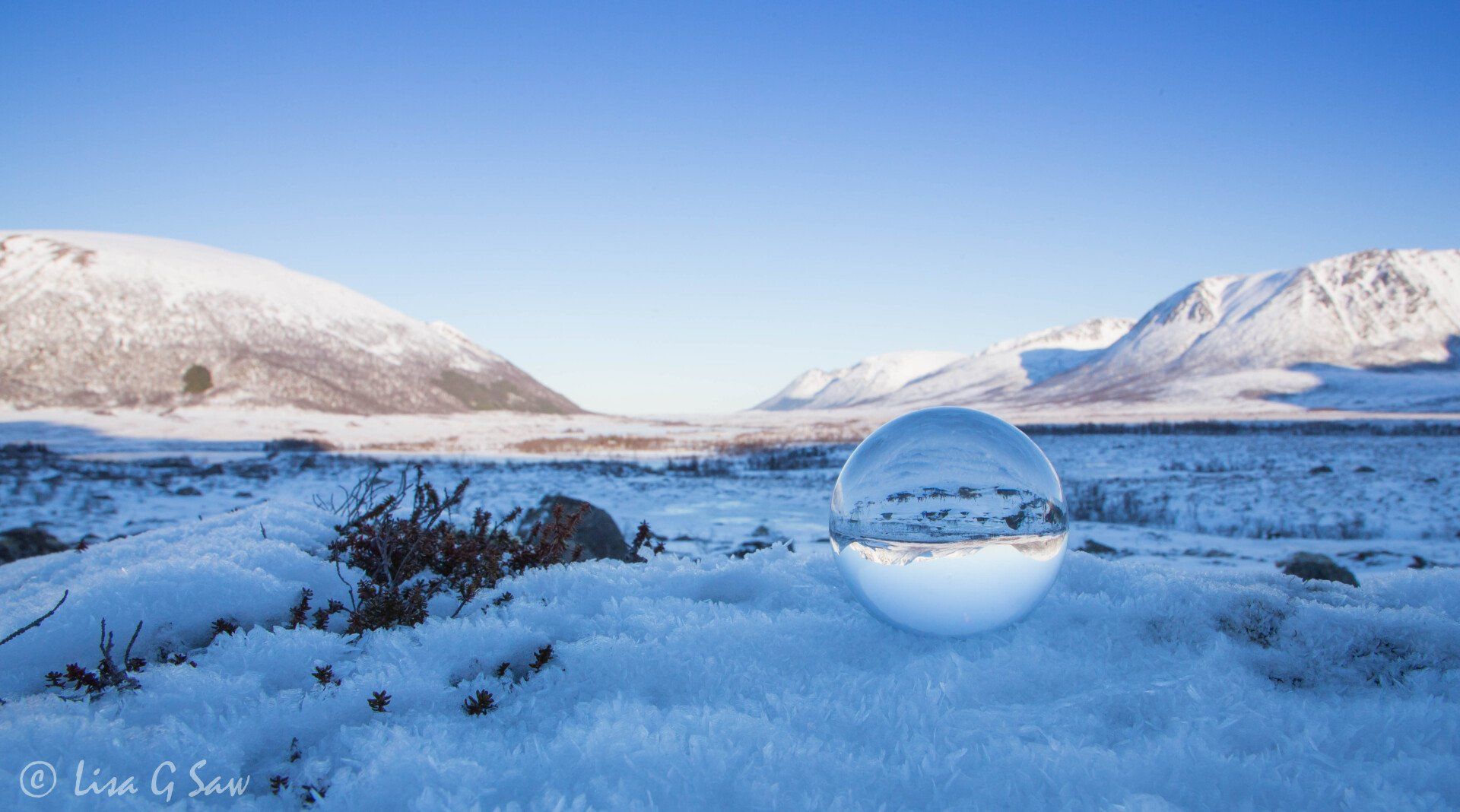 Glass ball with snow covered mountains and ice