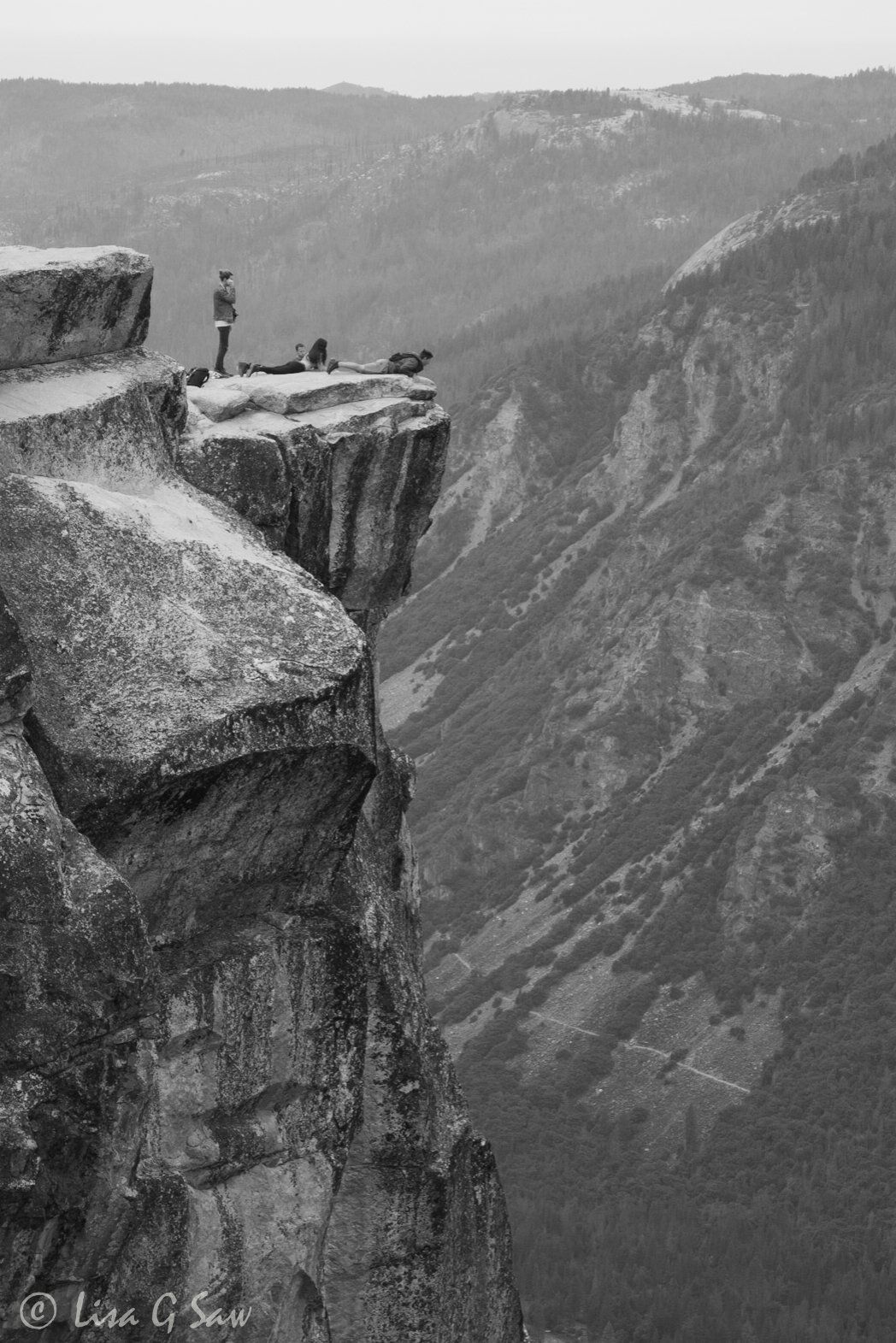 People peering over the edge at Taft Point (black and white)