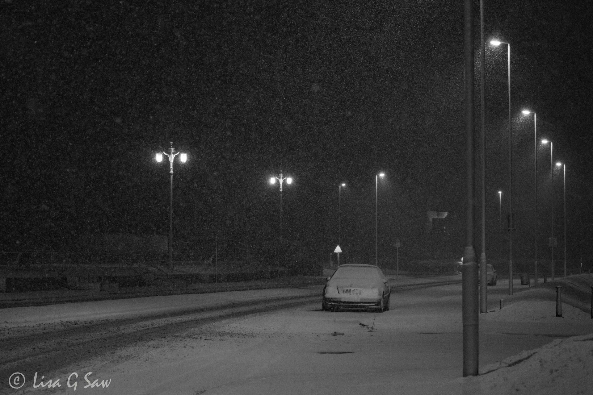 Car and street lights at night, snowing