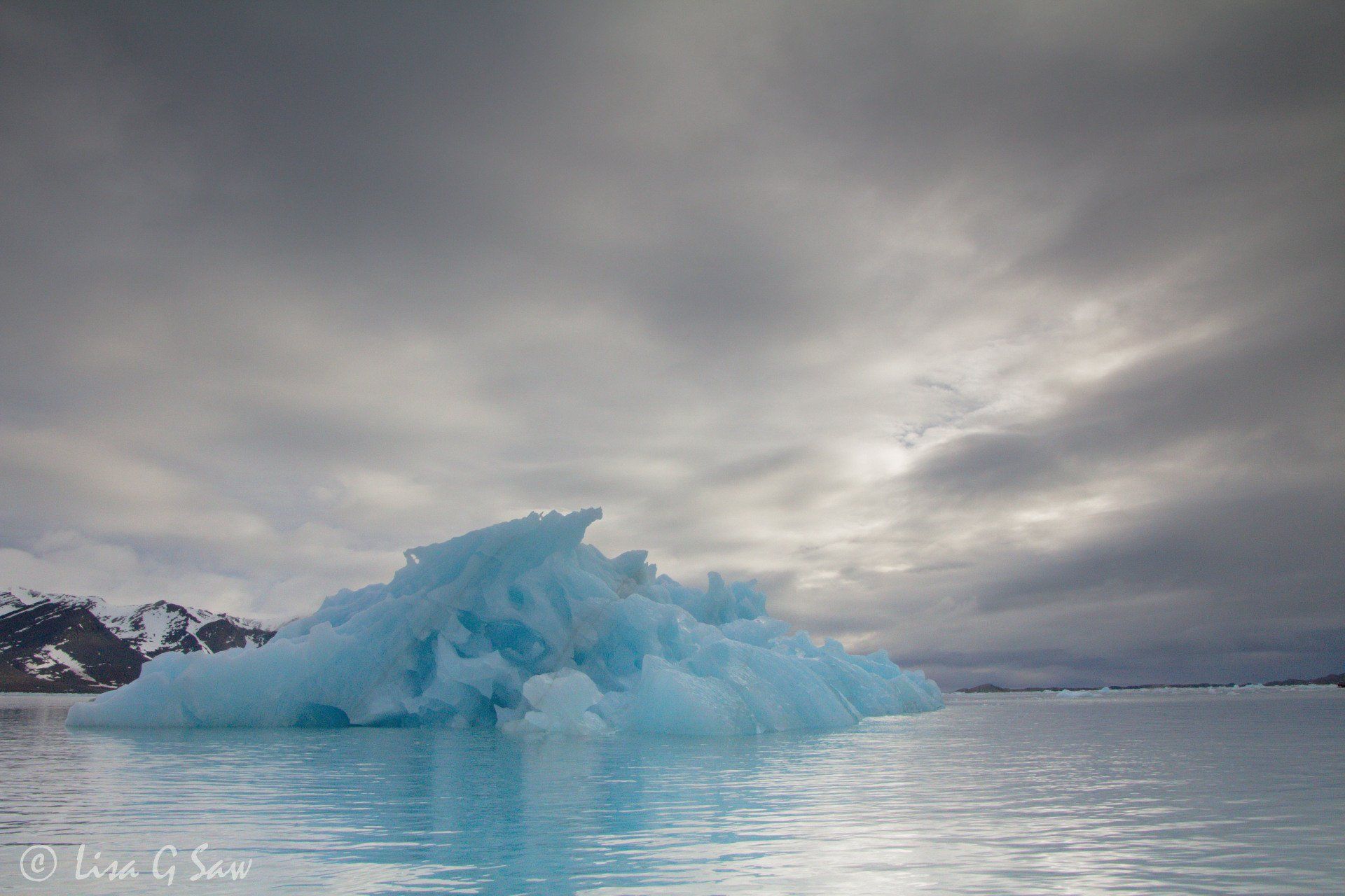 Blue iceberg in water from Monaco Glacier, Svalbard