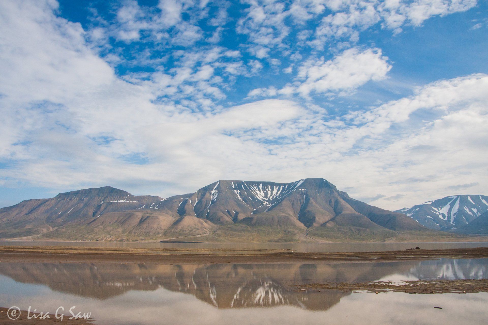 Mountains in summer reflected in water in Svalbard