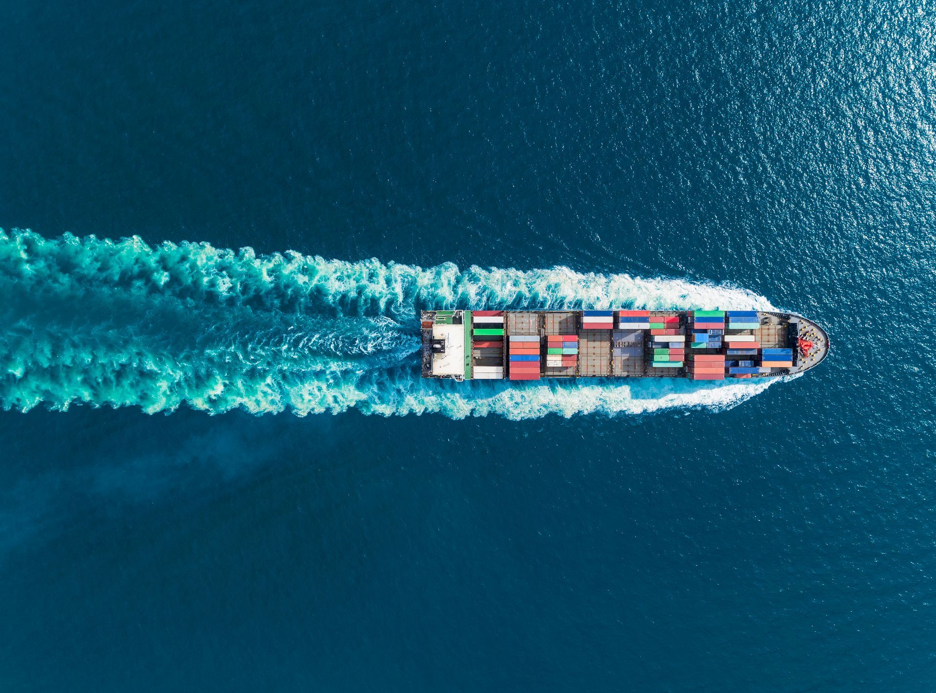 An aerial view of a large container ship floating on top of a body of water.