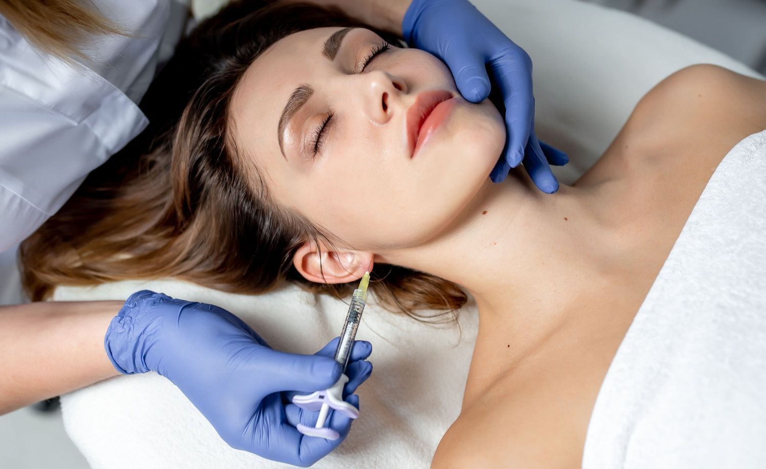 A woman is getting a botox injection in her face.