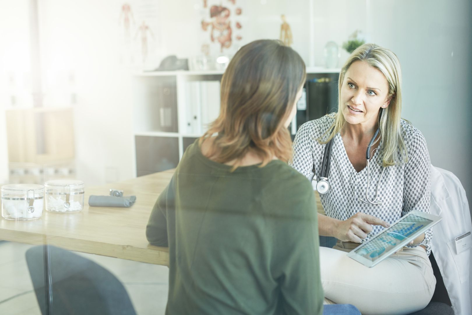 Cropped shot of a female doctor showing her patient something on her digital tablet