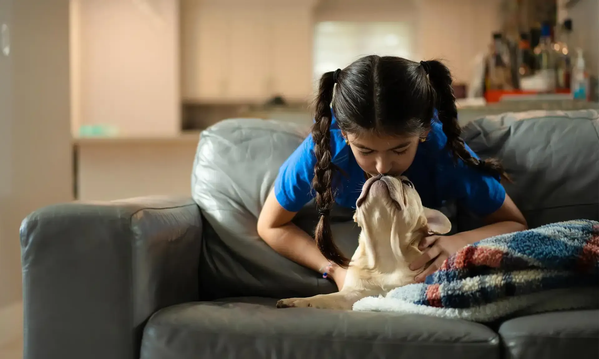 A girl kissing her pup