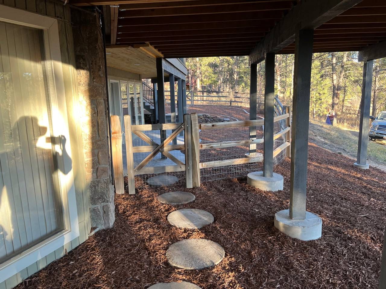 A porch with a wooden fence and stepping stones