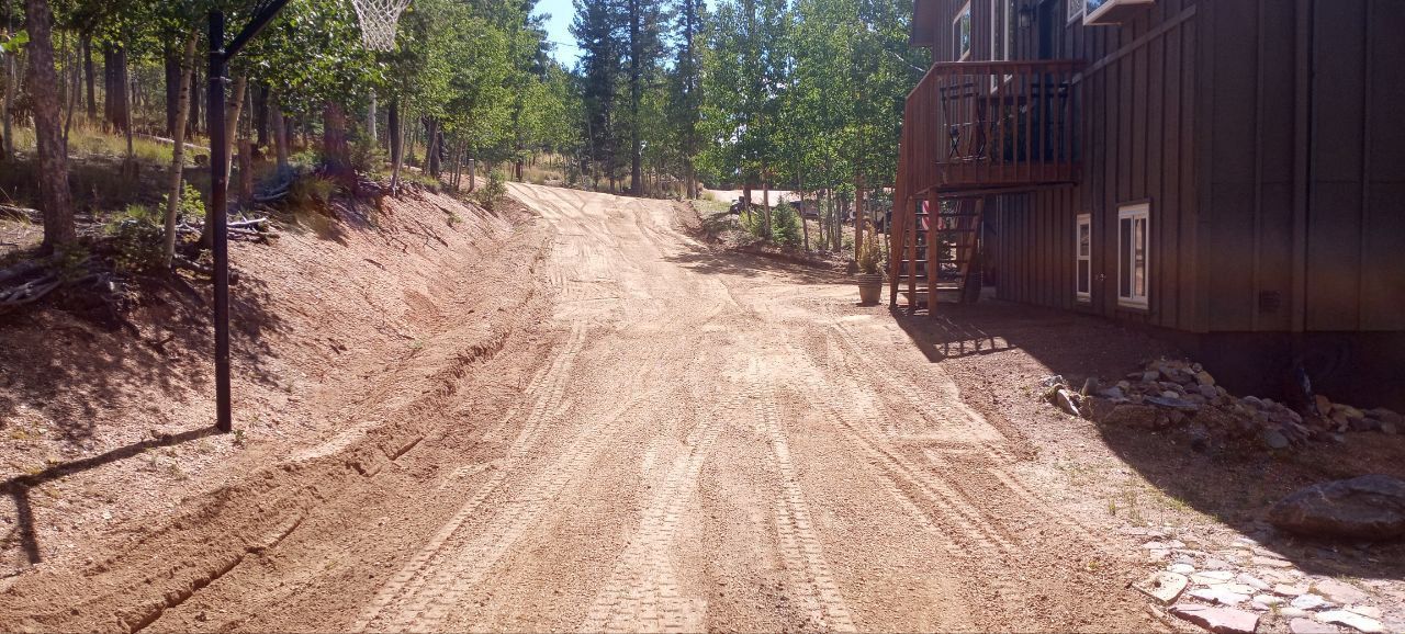 A dirt road leading to a house with the number 1 on it