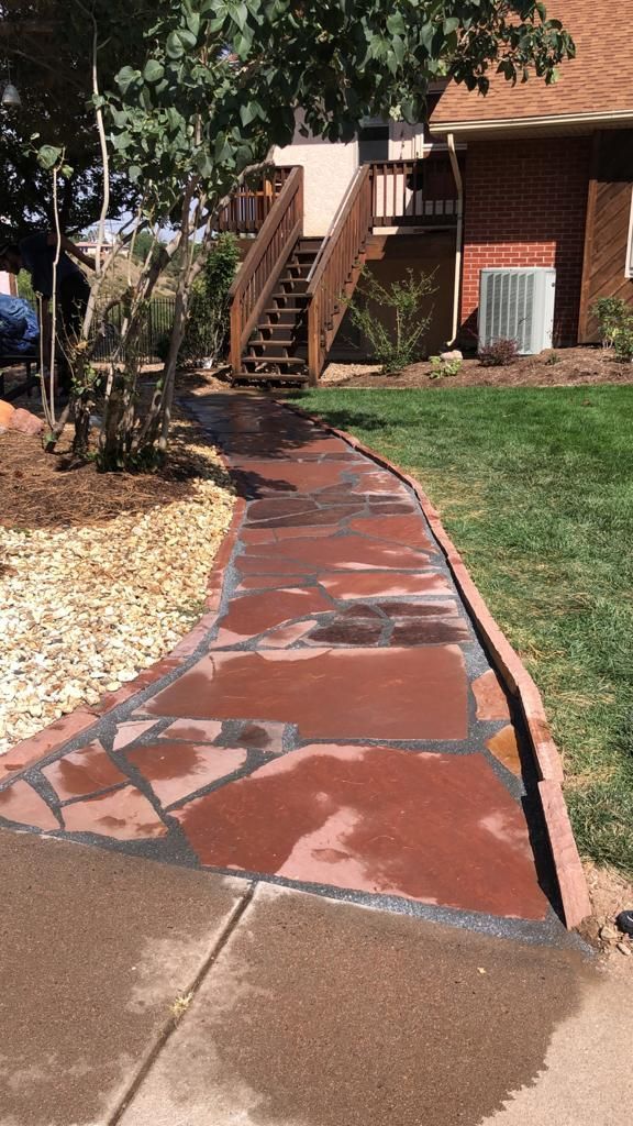 A stone walkway leading to a house with stairs