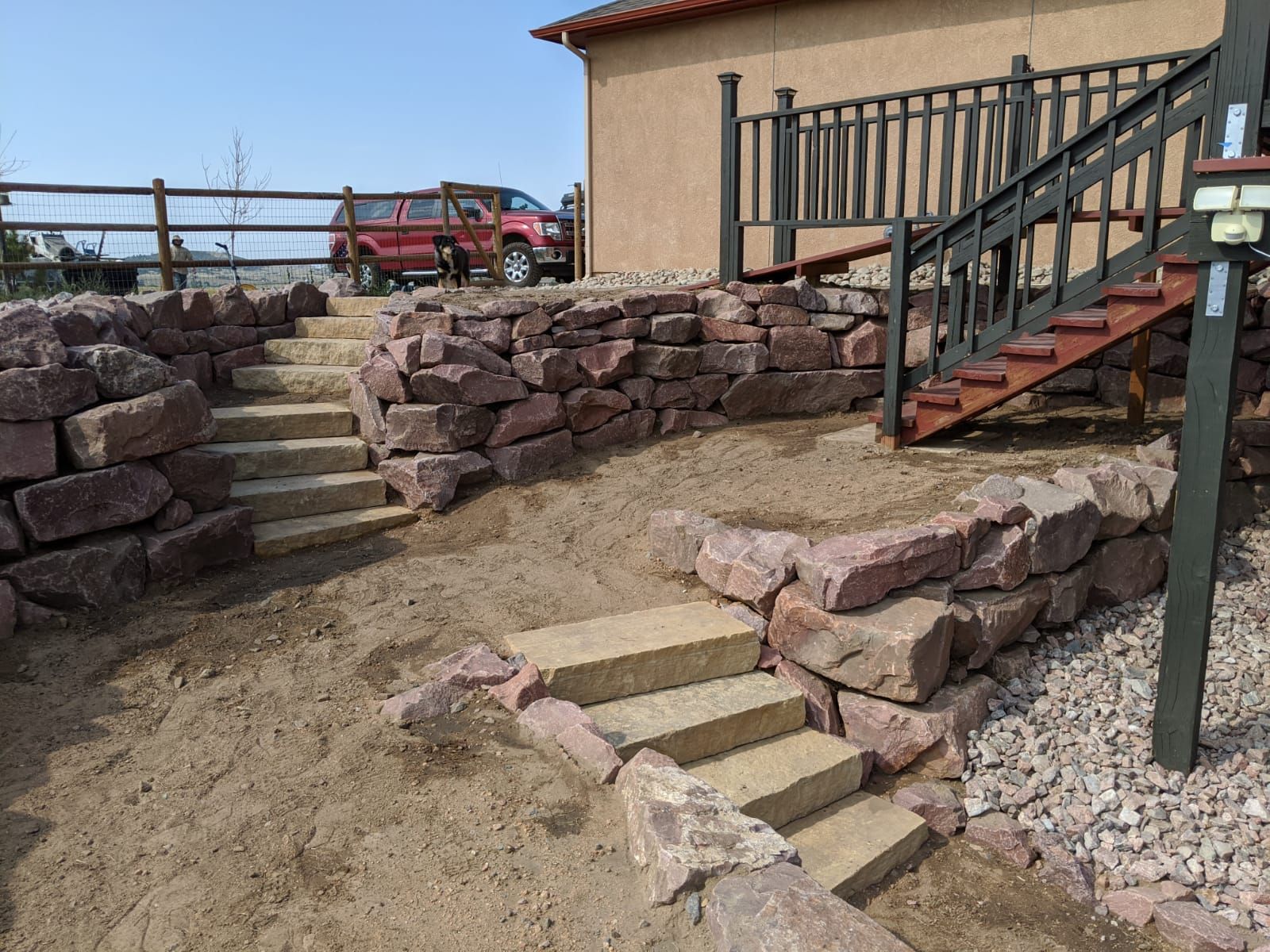 Stairs leading up to a house with a fence in the background