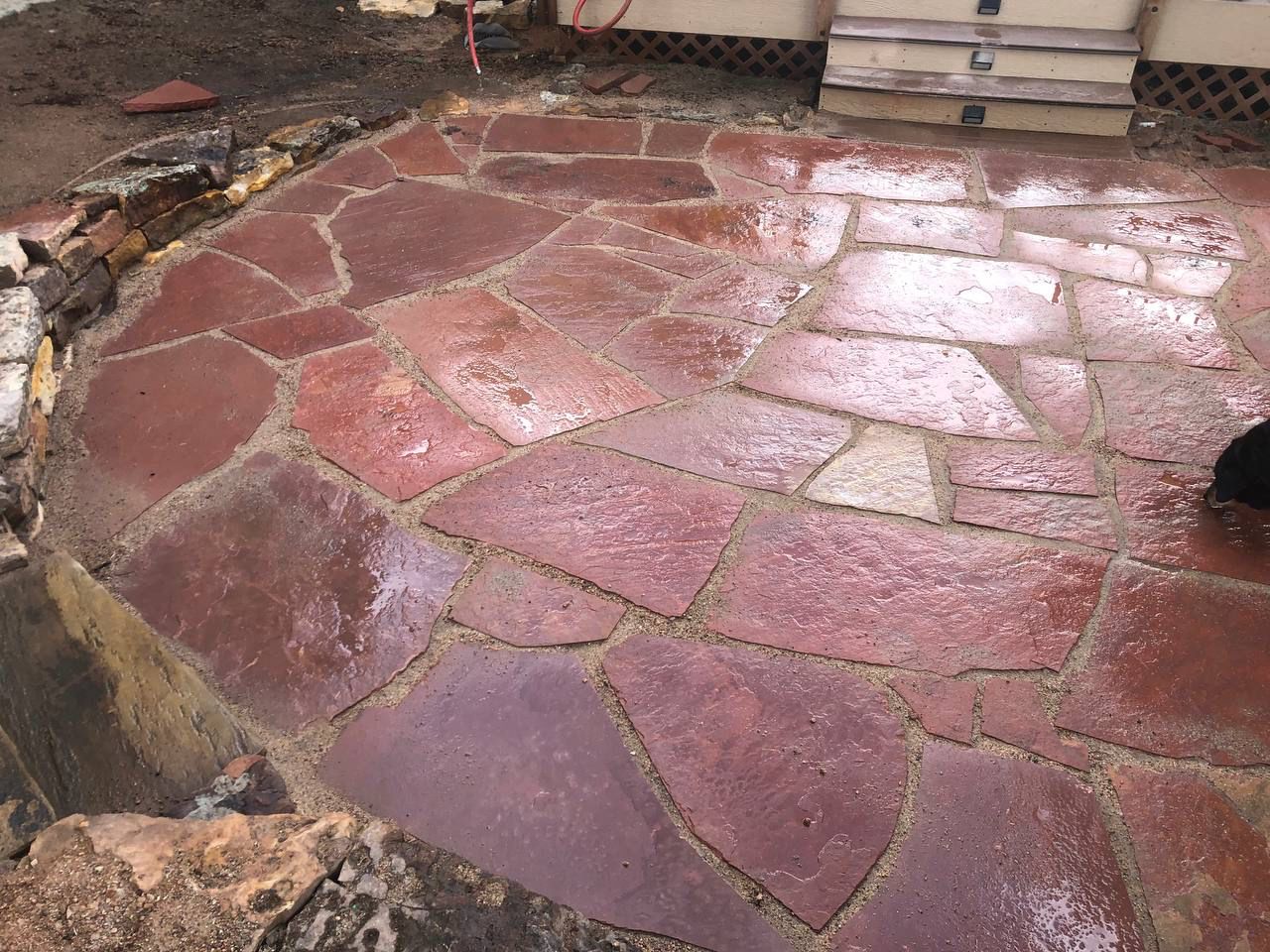 A brick patio with a circle in the middle of it
