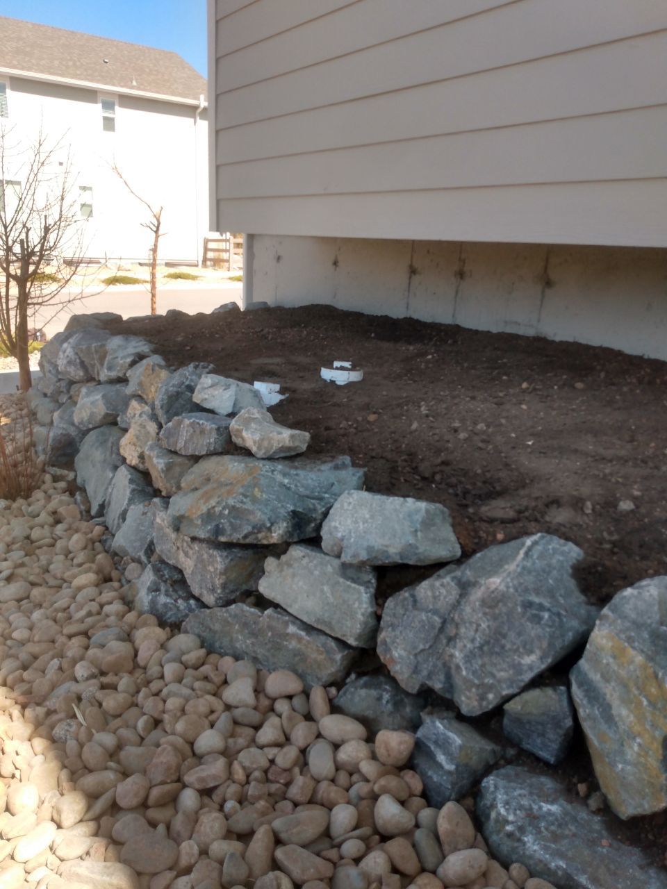 A pile of rocks sits in front of a house
