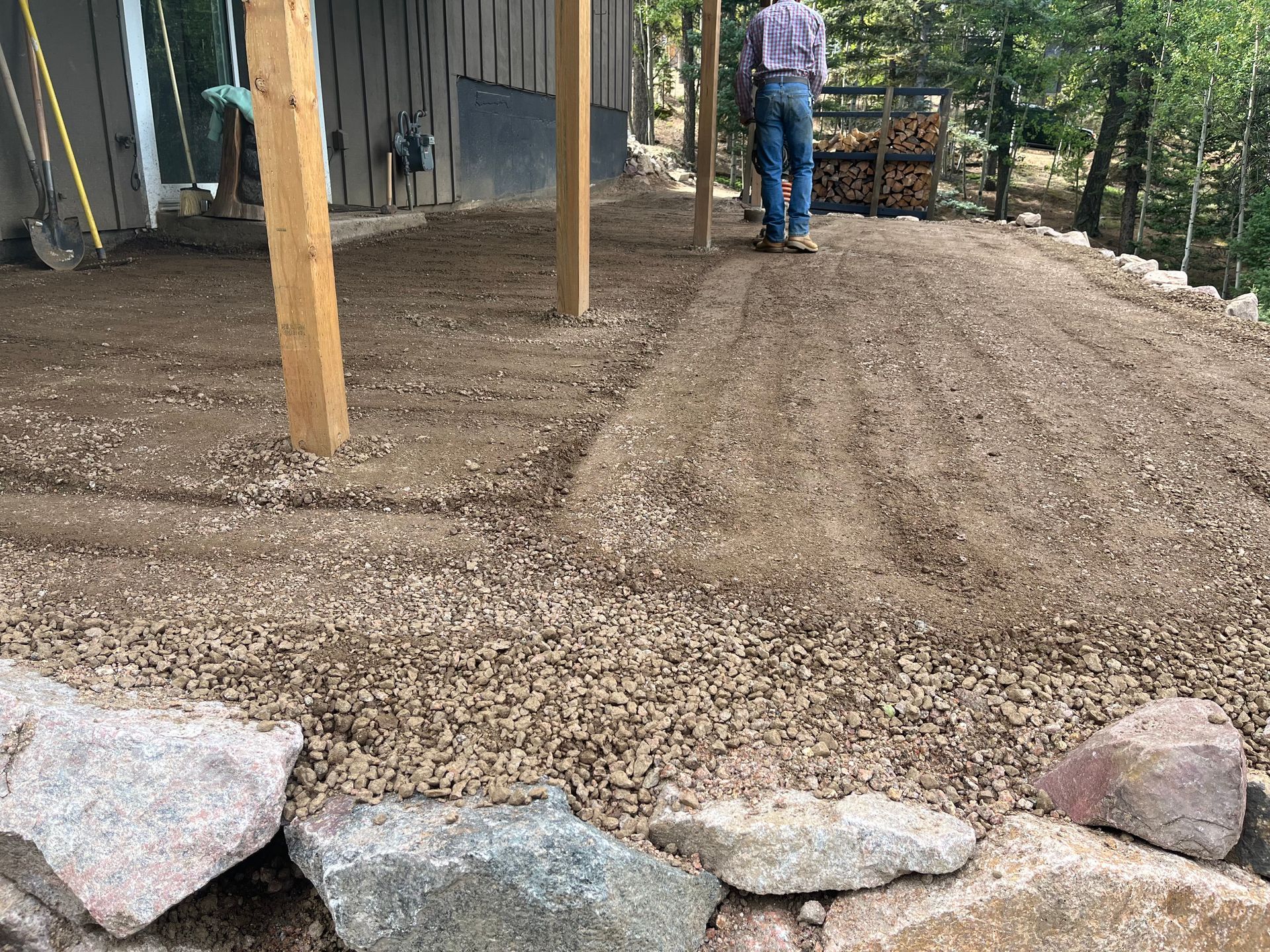 A man is standing in a pile of dirt and rocks.