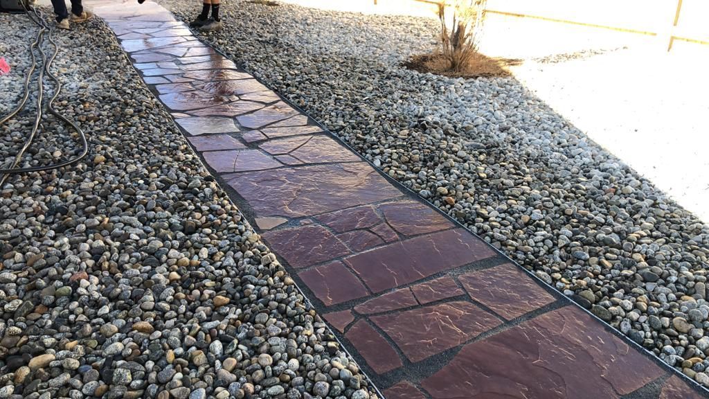 A stone walkway is surrounded by rocks and gravel.