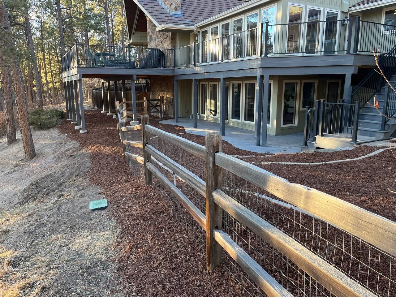 A large house with a wooden fence in front of it.