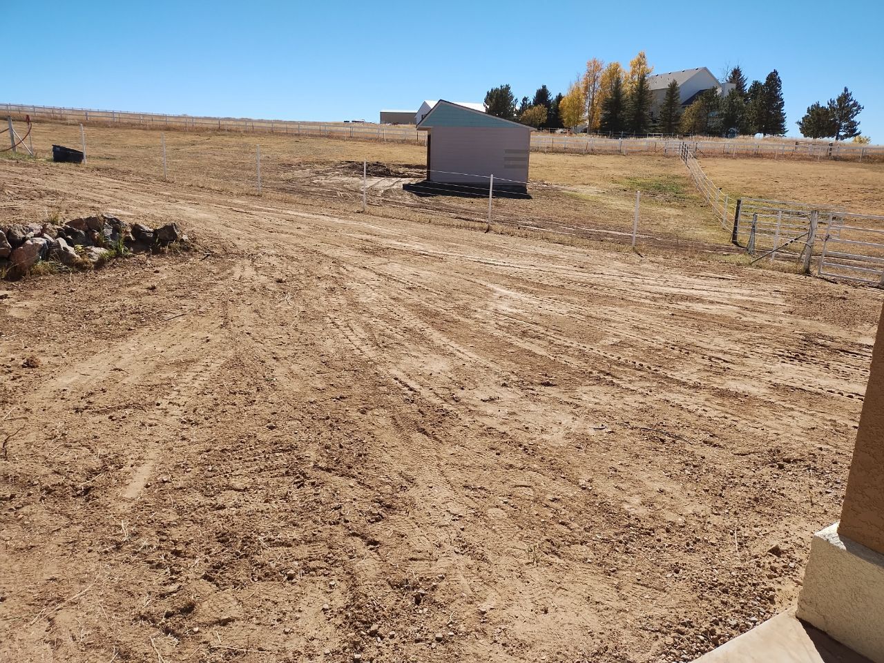 A shed sits in the middle of a dry field