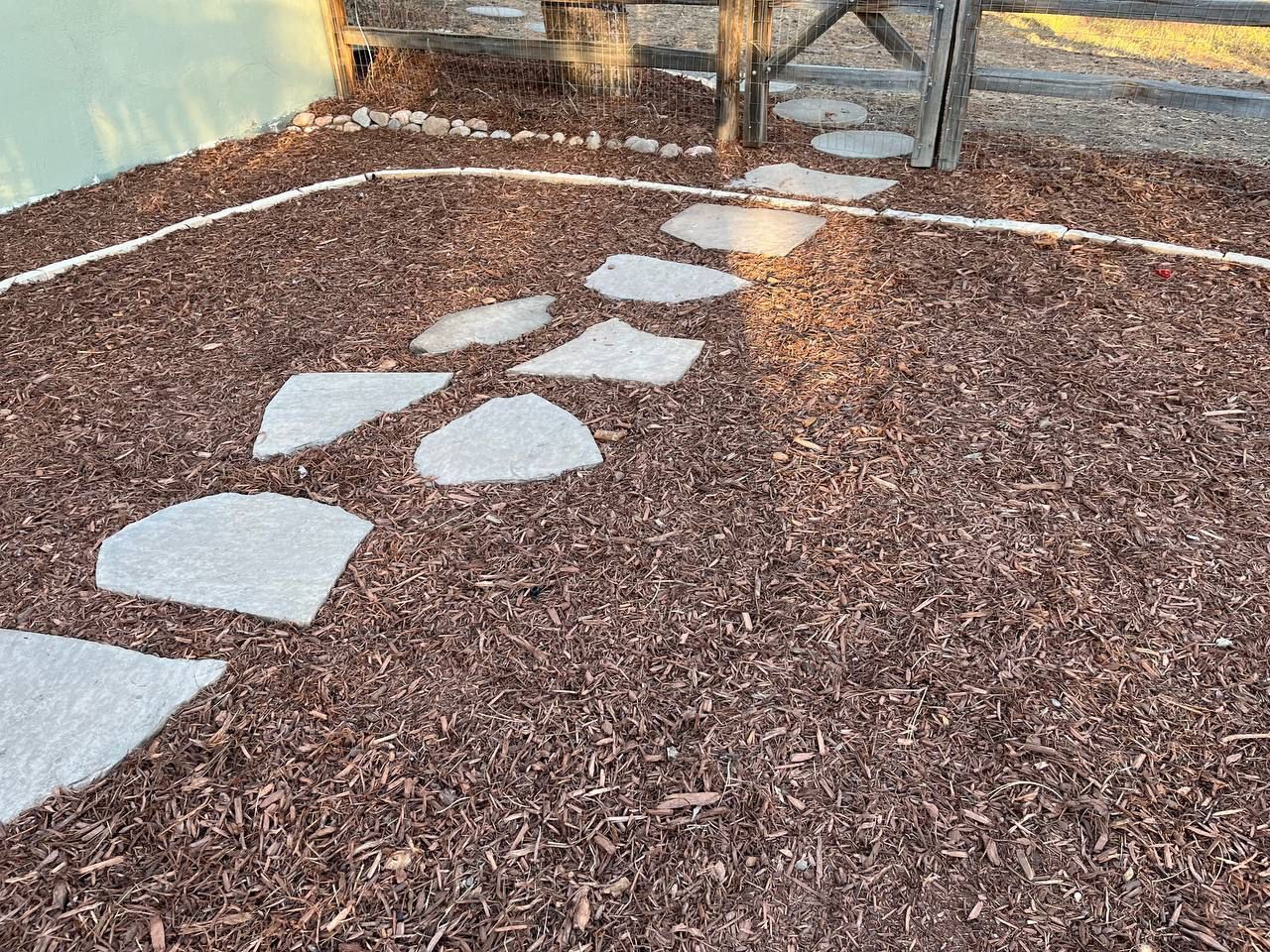 A walkway made of brown mulch and stepping stones