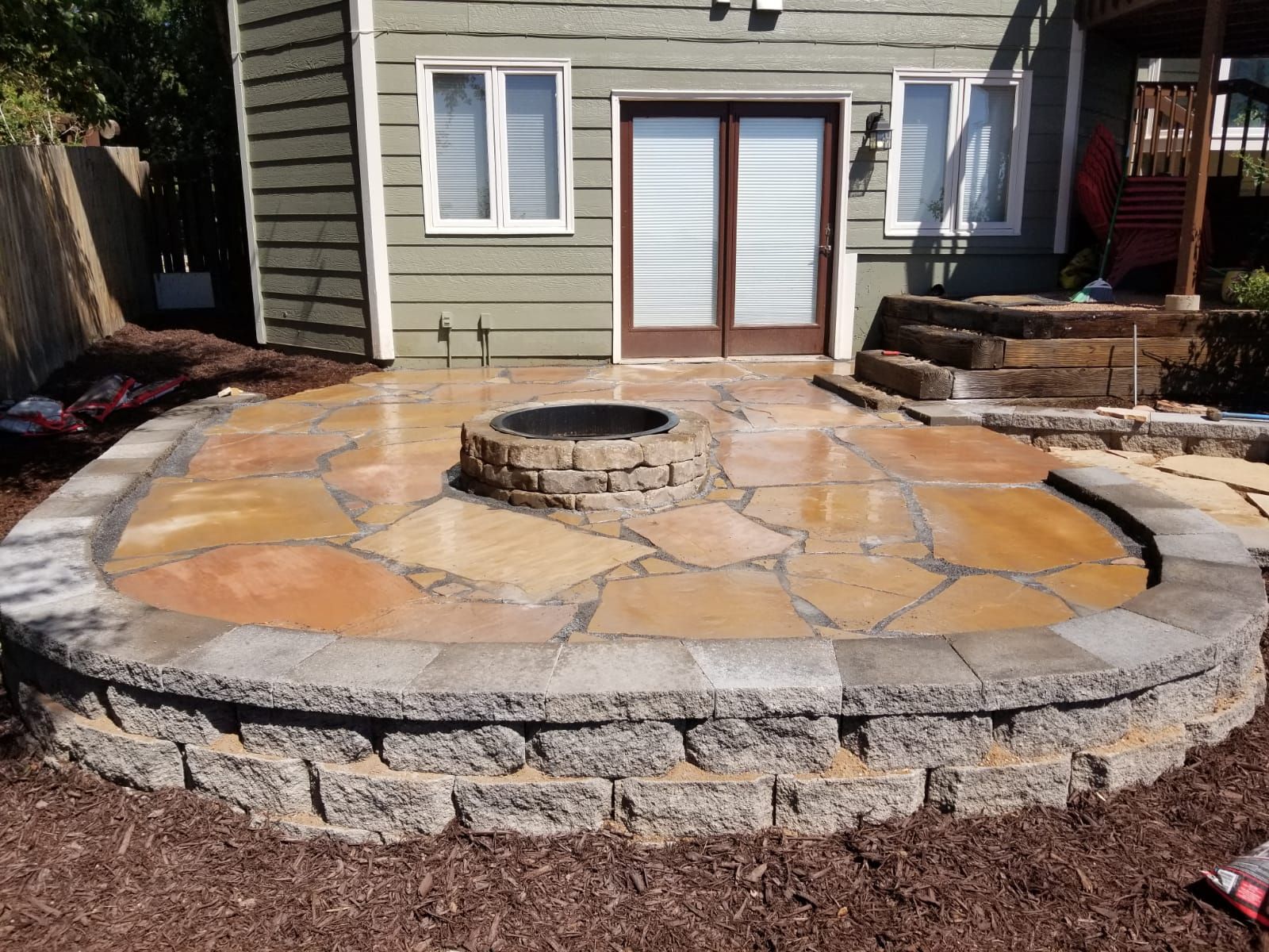 A patio with a fire pit in the middle of it