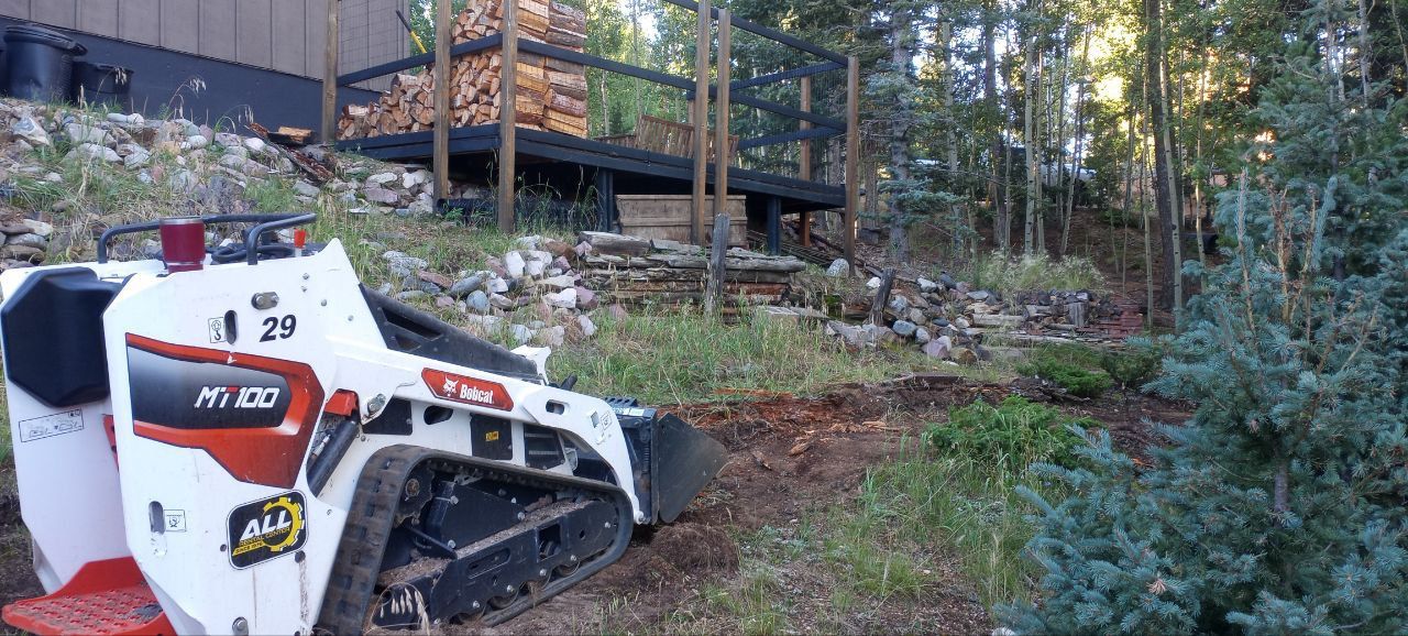 A bulldozer is parked in a yard with a bridge in the background.