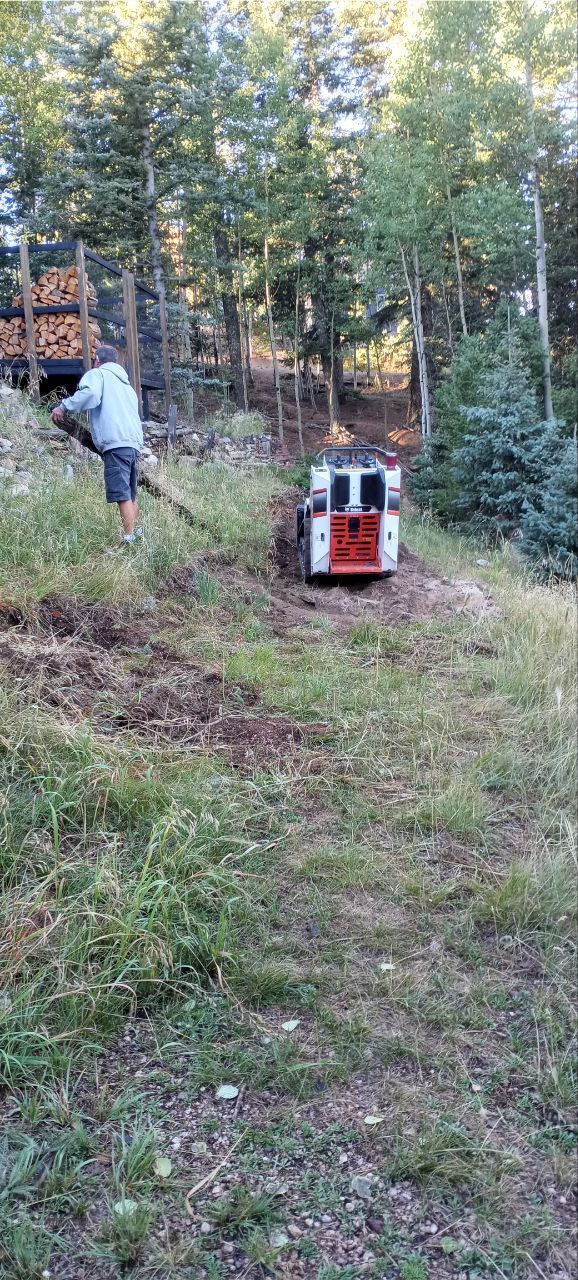 A man is standing next to a tractor in a field.