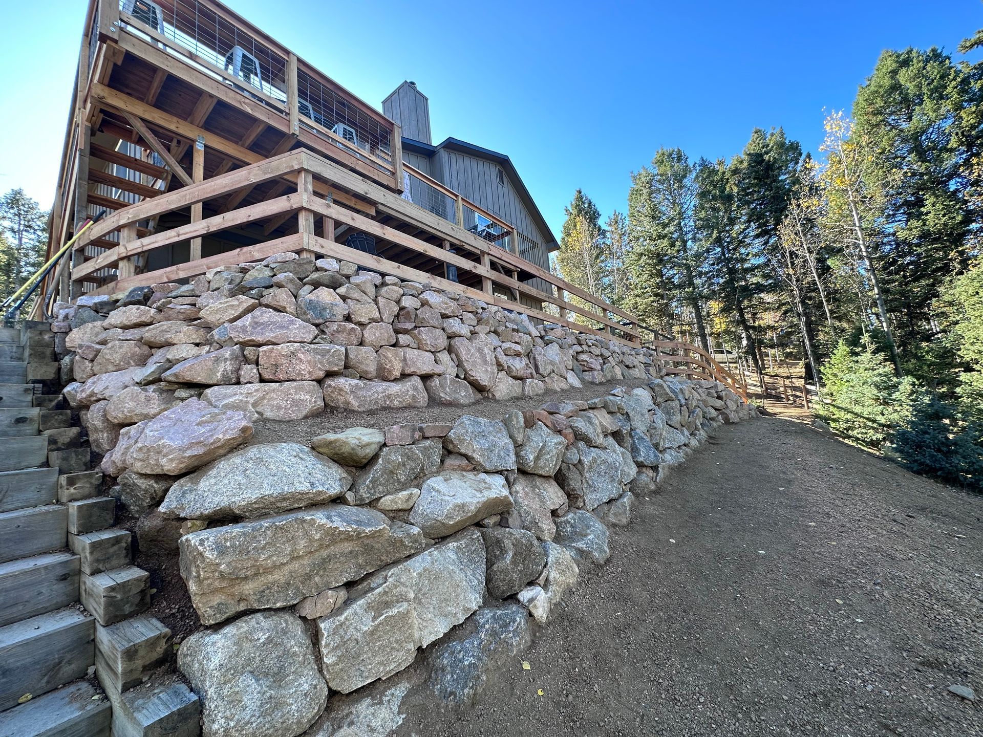 A stone wall with stairs leading up to a house