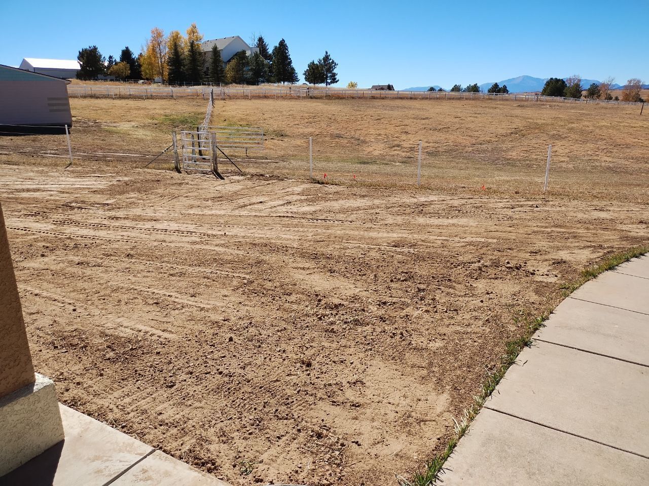 A fenced in field with a house in the background