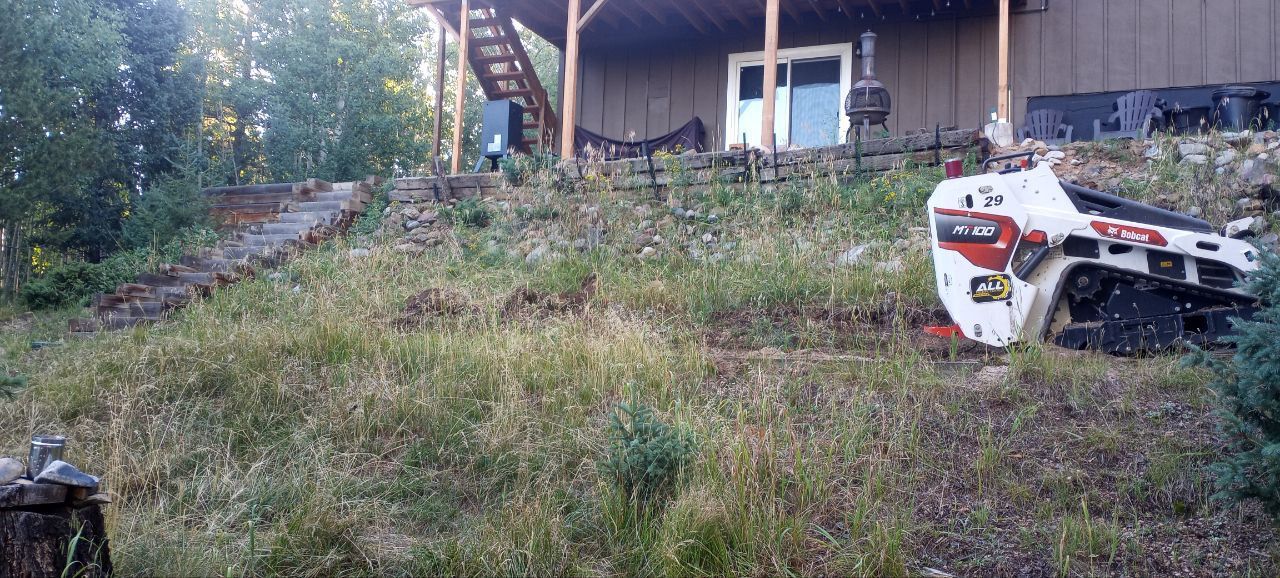 A bobcat tractor is parked in front of a house