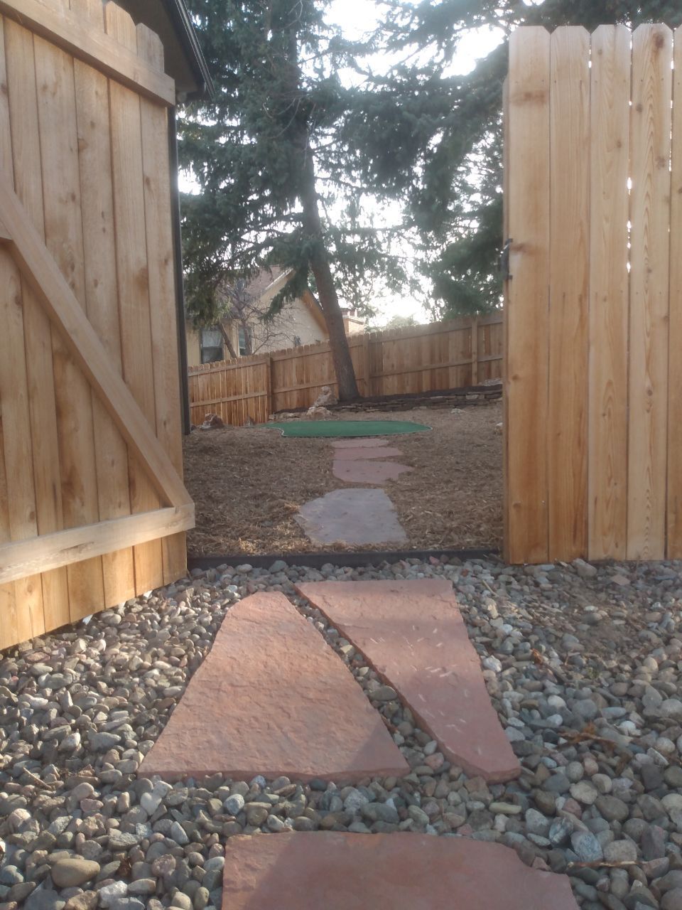 A wooden fence with a stone walkway leading to it