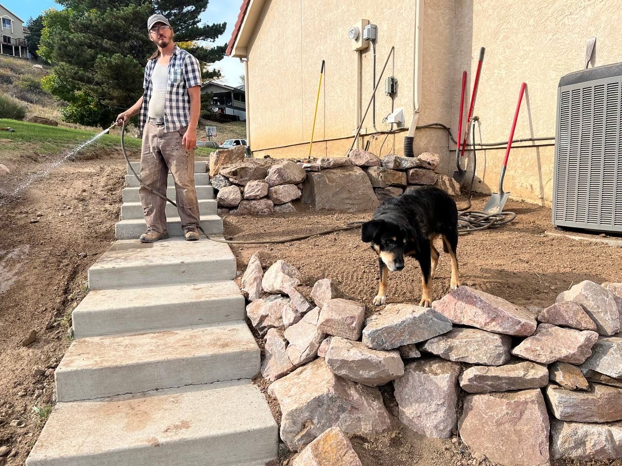 A man standing on a set of stairs next to a dog