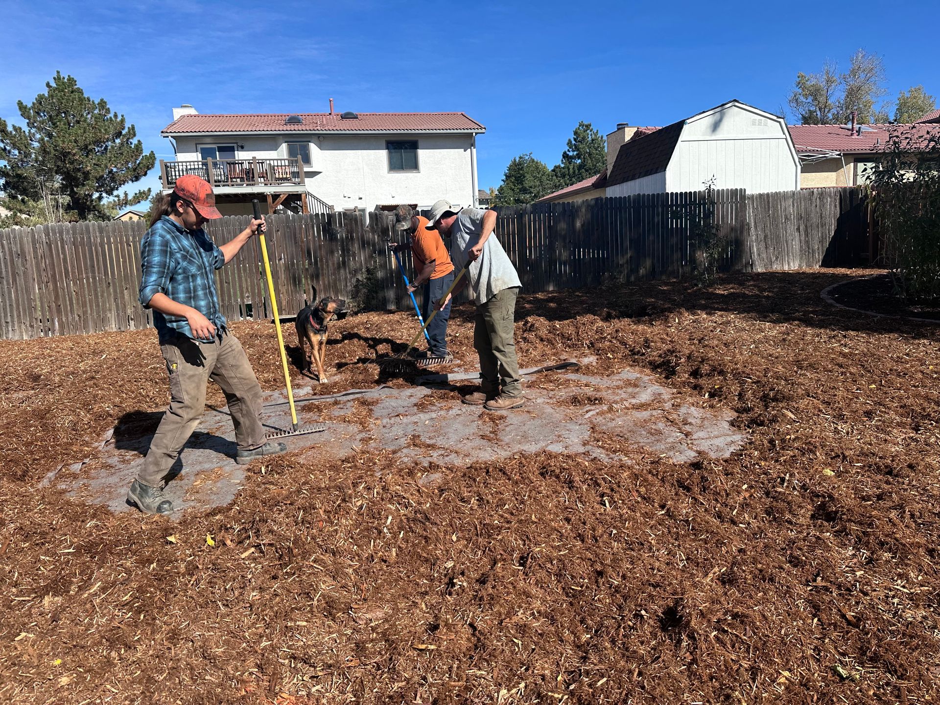 A group of men are working in a muddy yard in front of a house