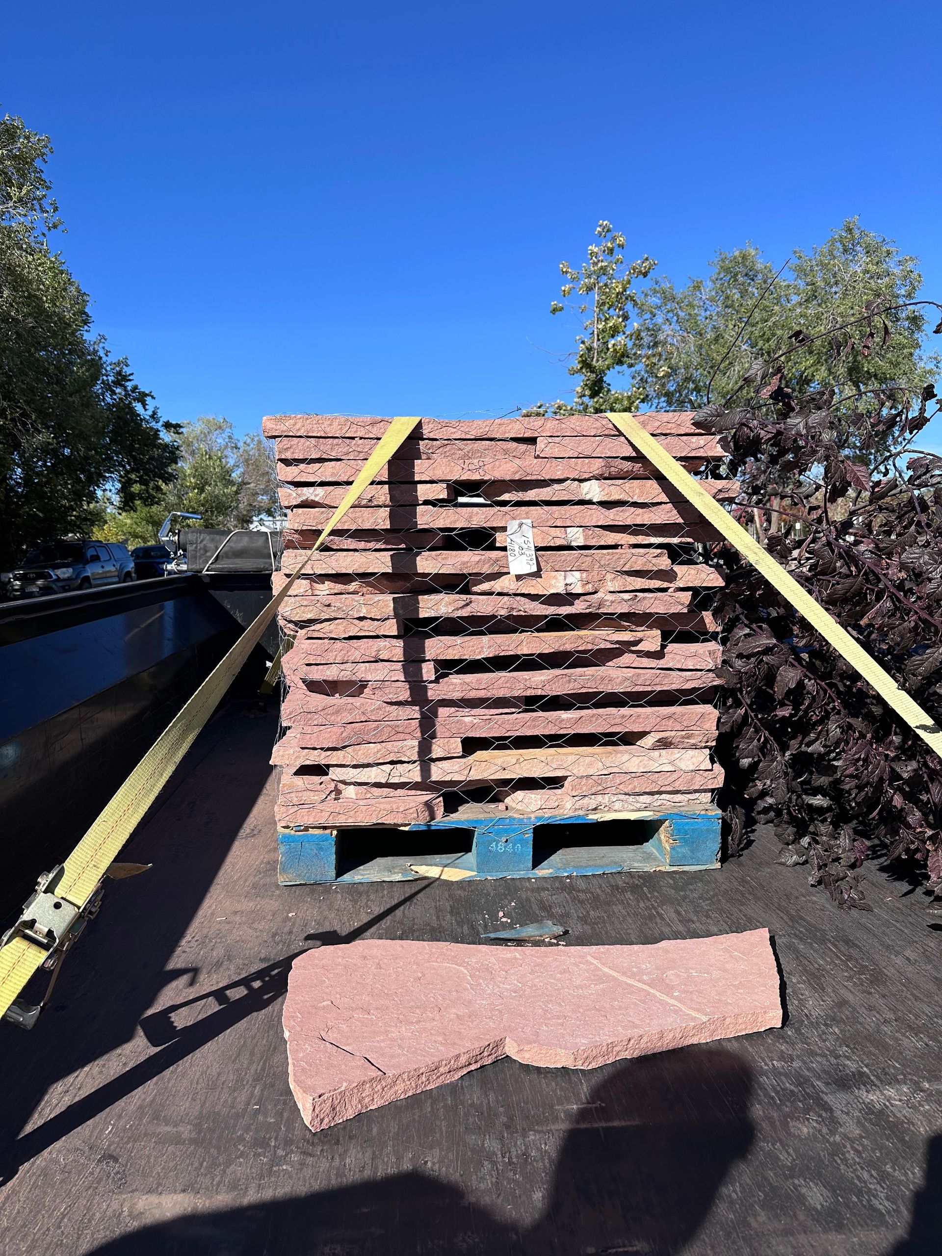 A pallet of bricks is tied together with yellow straps
