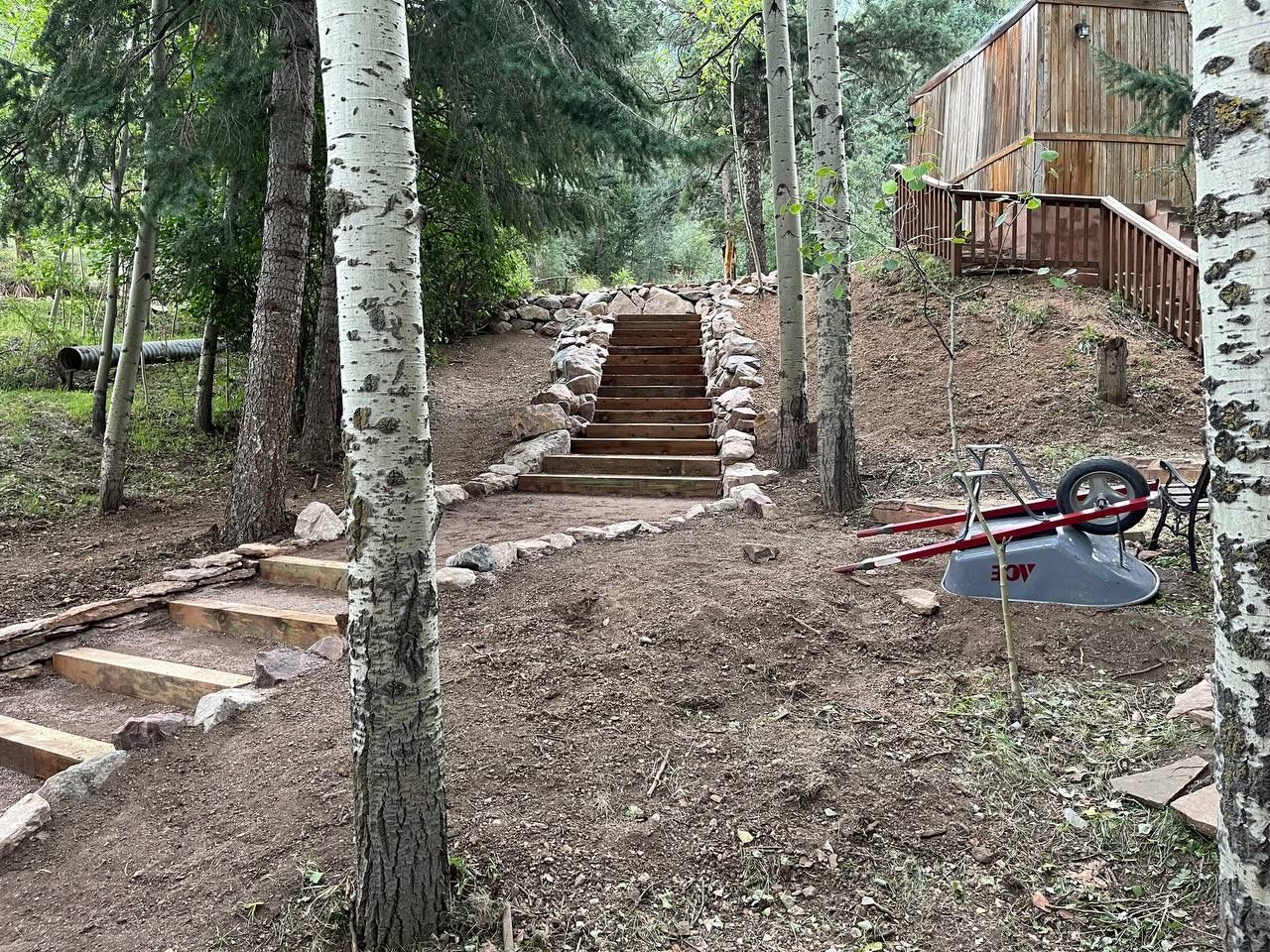 There are stairs leading up to a house in the woods.