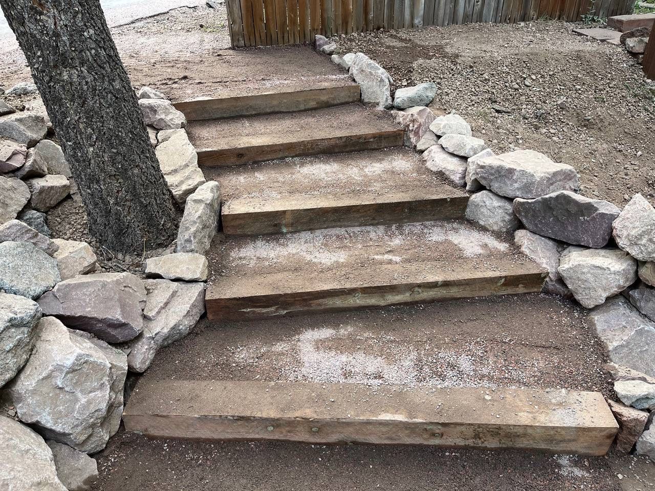 A set of stone stairs surrounded by rocks and dirt.