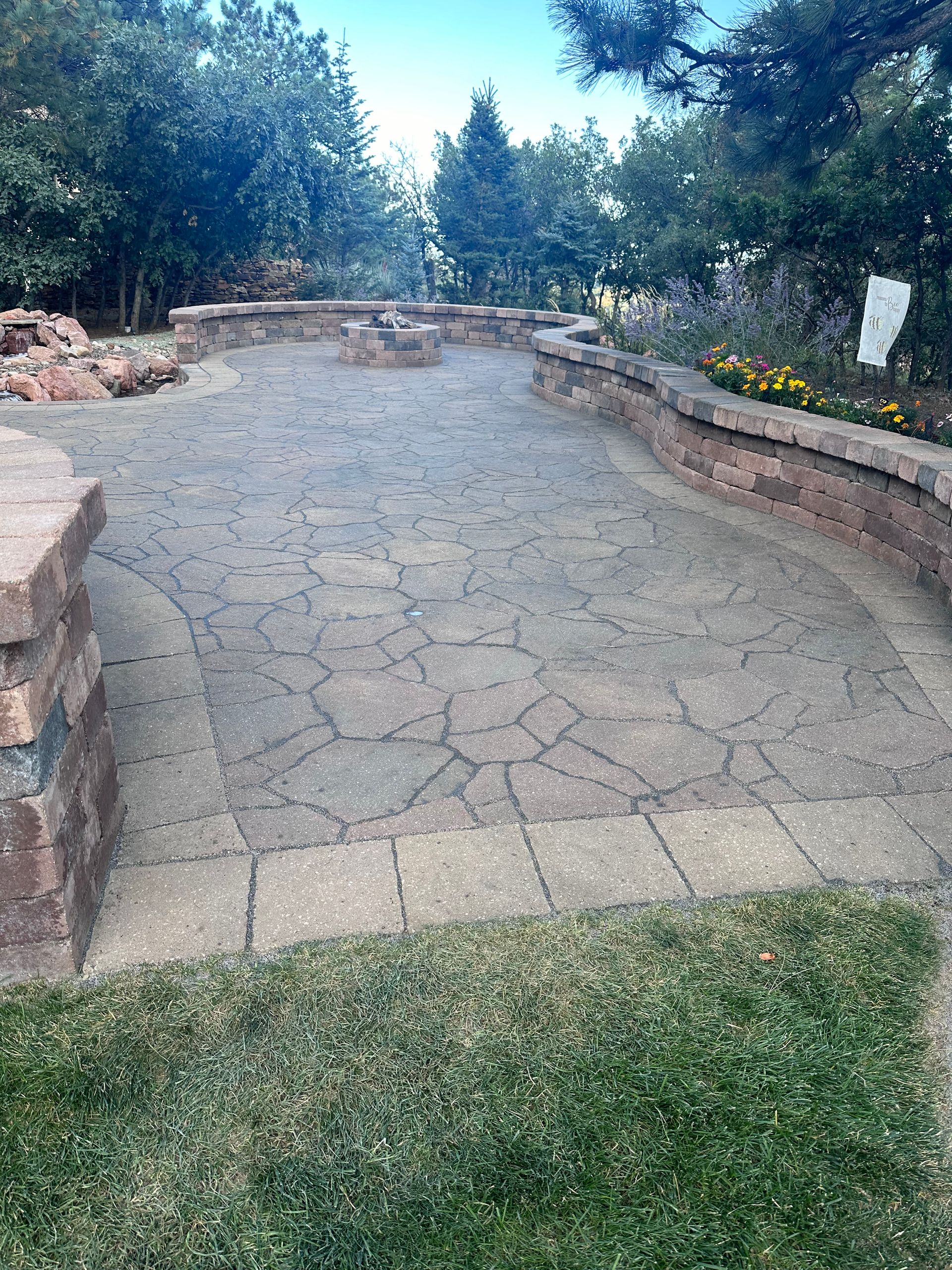 A brick walkway with a fire pit in the background