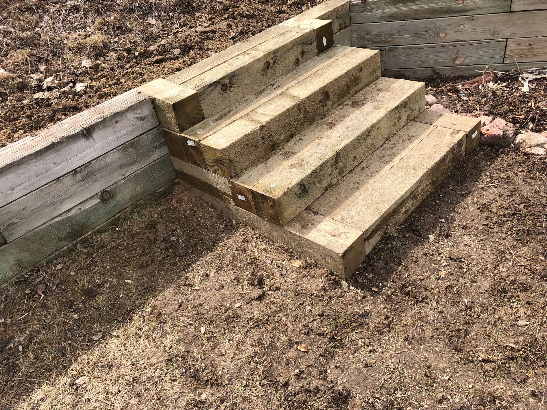 A set of wooden steps sitting on top of a pile of wood chips.