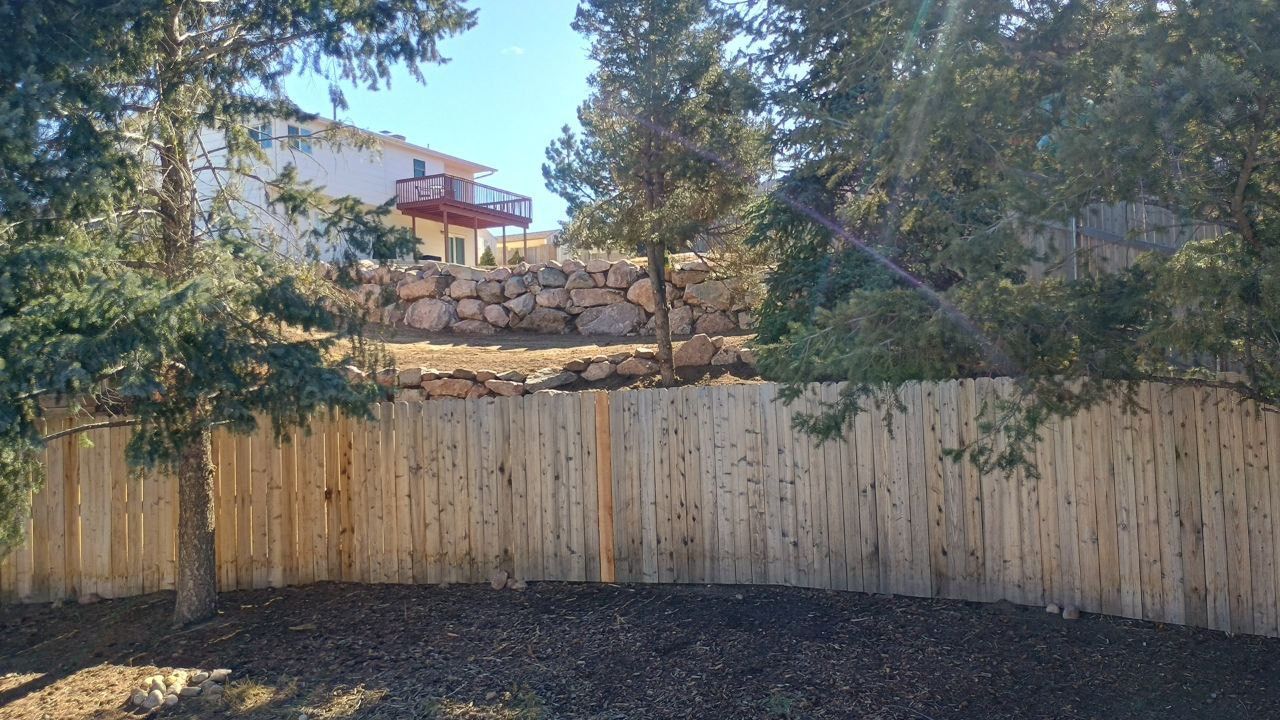 A wooden fence with a house in the background