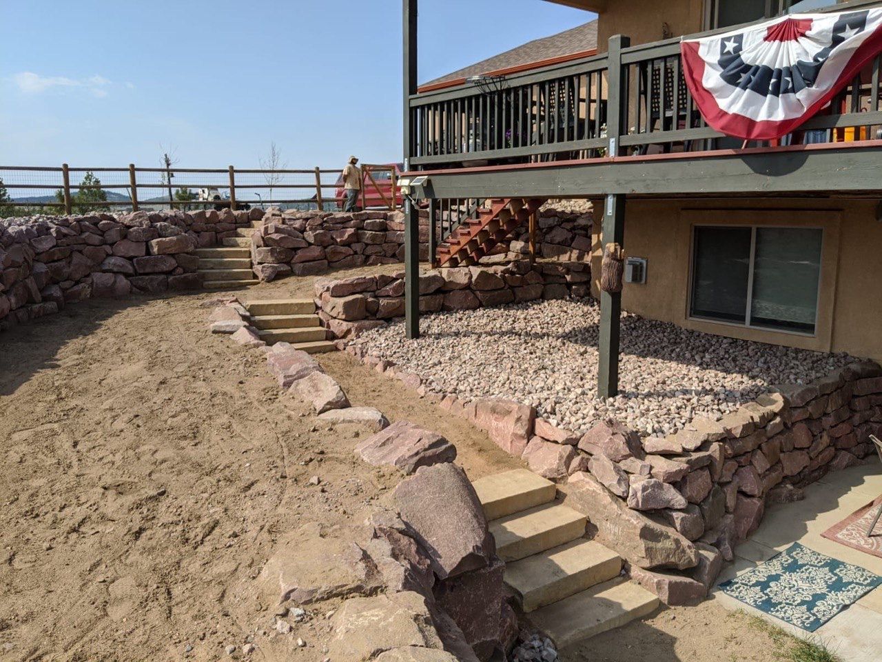 Stairs leading up to a house with a flag on the deck