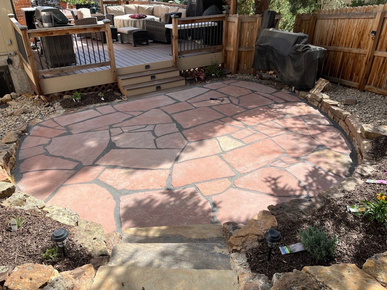A stone patio with a wooden fence in the background