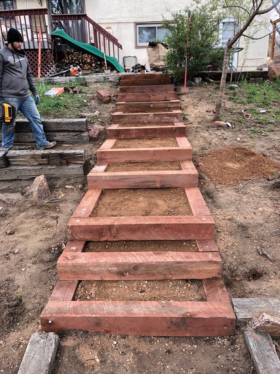 A man is standing next to a set of stairs that are being built.