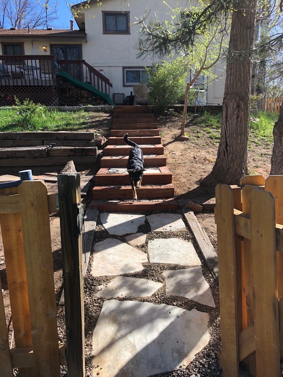 A stone walkway leads to a house with stairs leading up to it