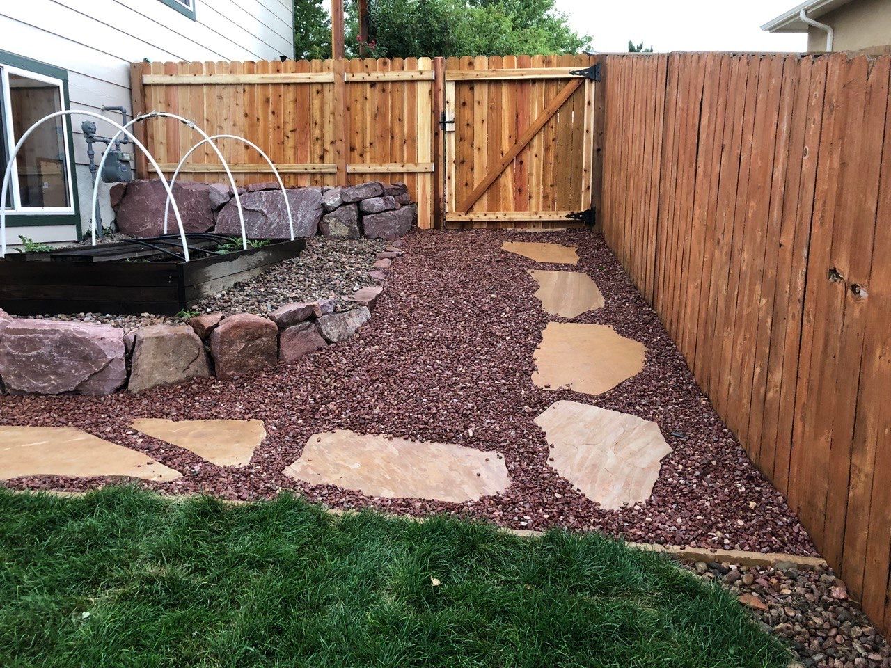 A backyard with a wooden fence and a fountain