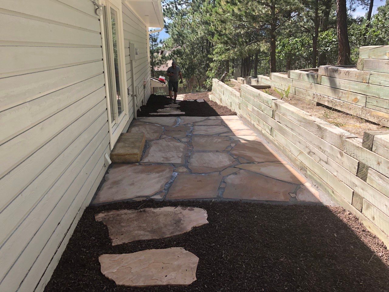 A white house with a stone walkway leading to it.