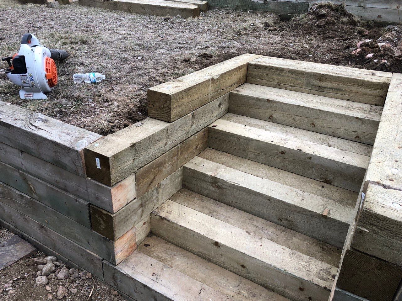 A set of concrete stairs built into a wooden wall.