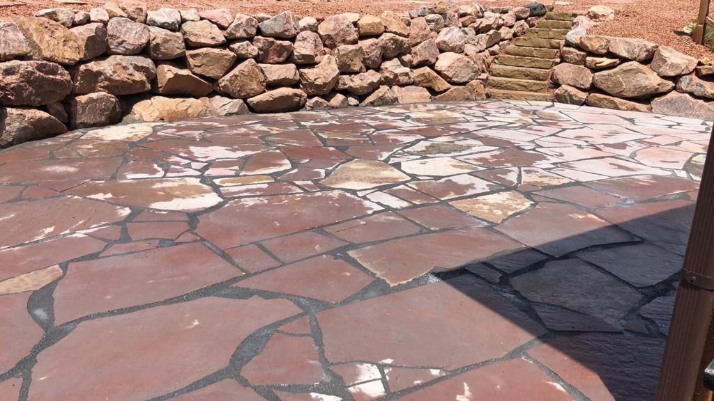 A stone patio with a stone wall in the background