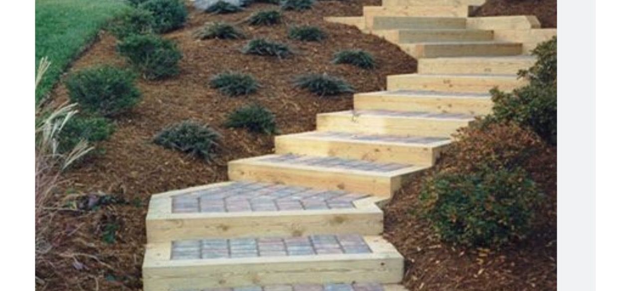 A set of wooden stairs leading up to a hill.