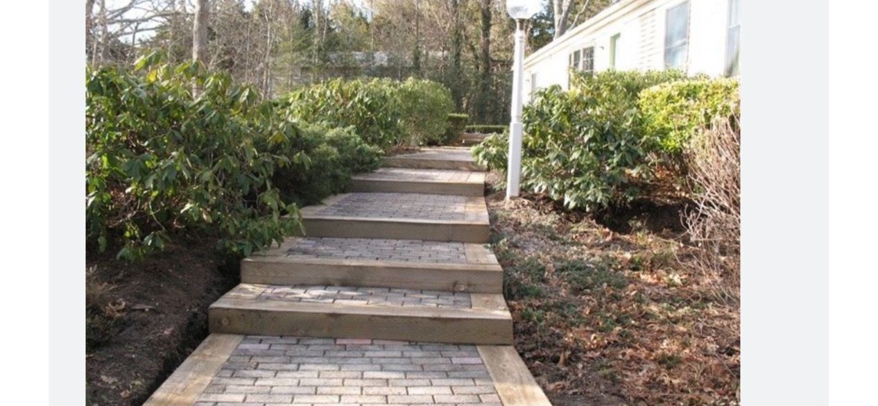 A brick walkway with steps leading up to a house